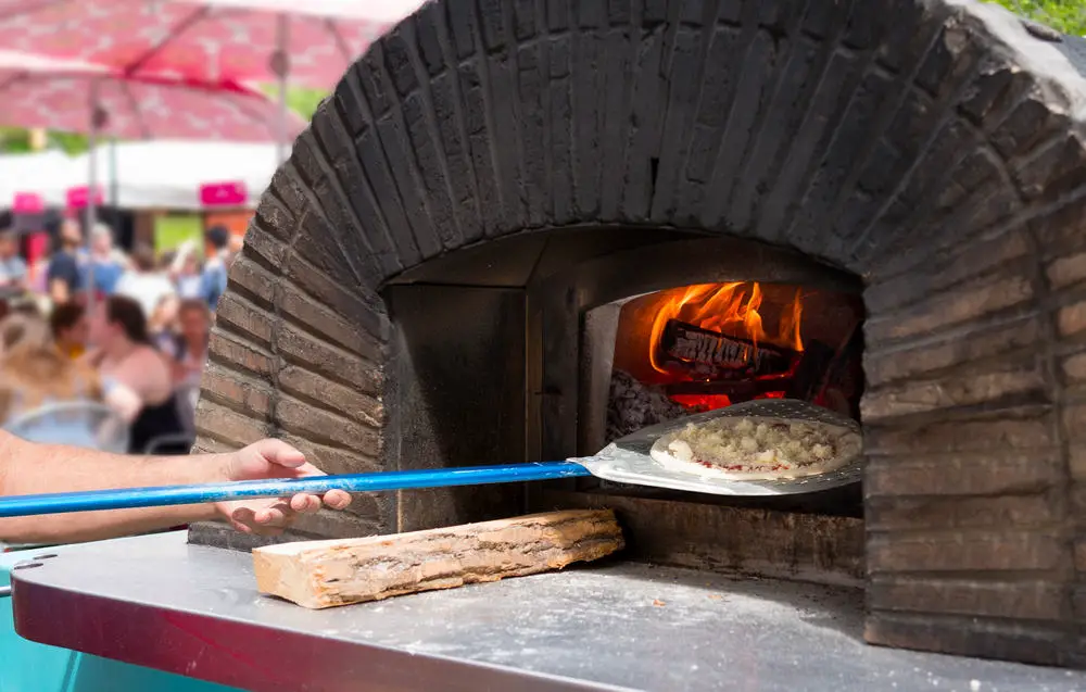 Pizza oven with a pizza being put in it