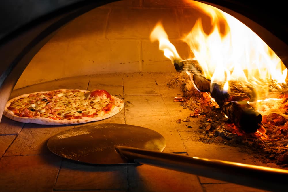Pizza cooking in wood fired oven